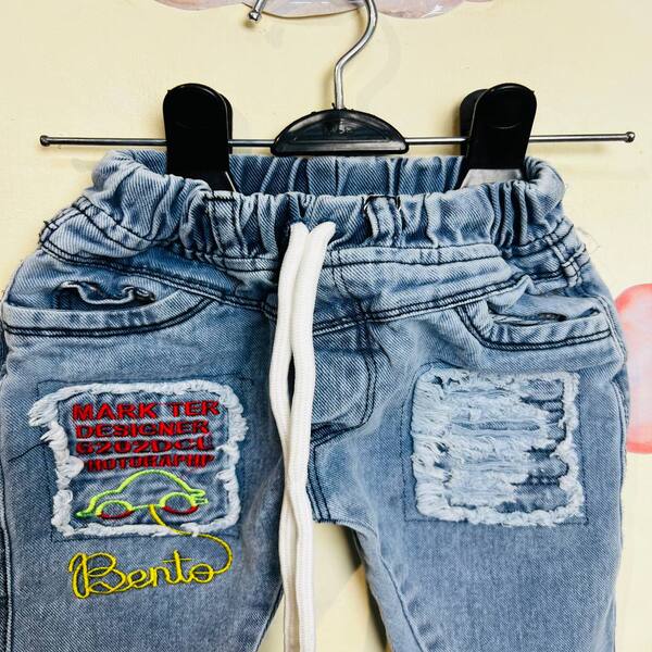 شلوار جین نوزادی پسرانه نقلی شلوار جین نوزادی پسرانه طرح ماشین از نمای نزدیک